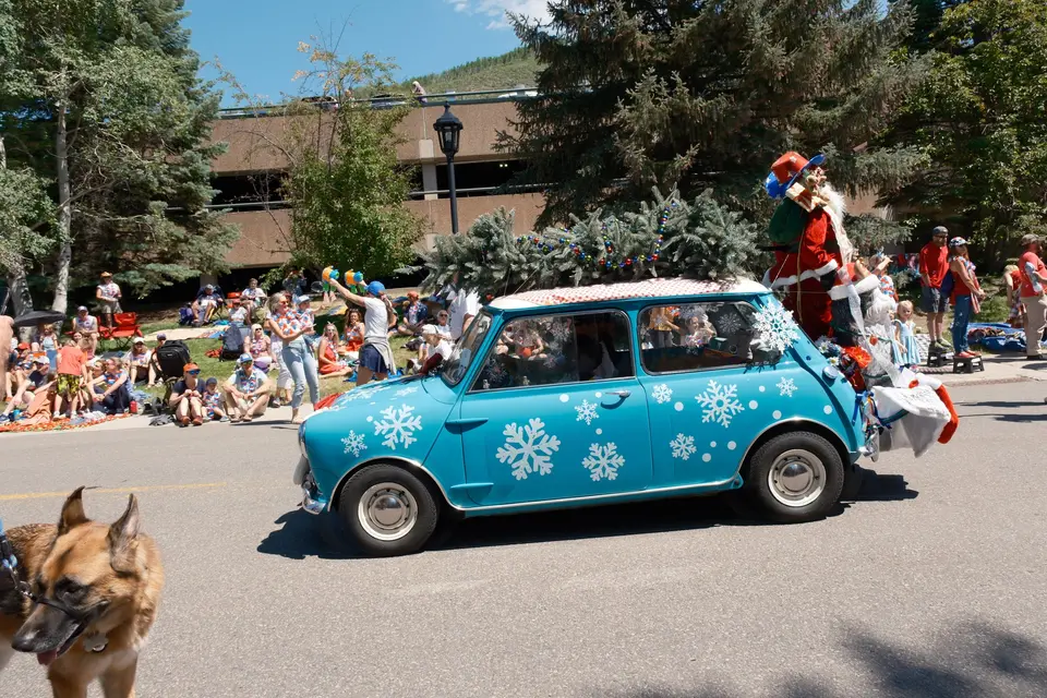 Light-blue Mini with snowflake decals and Santa riding on top in the Fourth of July parade