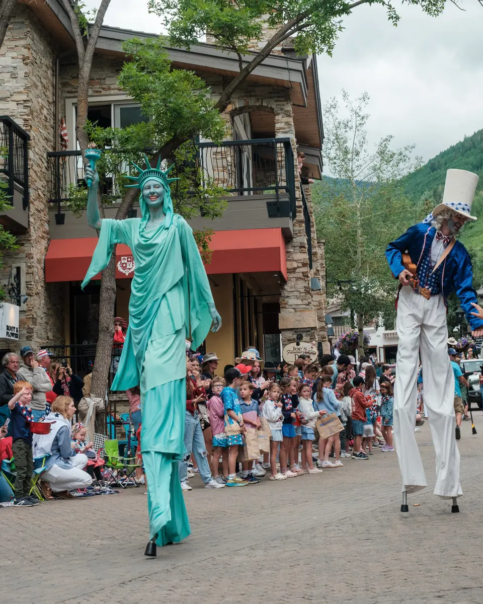Stilt walkers dressed as the Statue of Liberty and Uncle Sam in the parade