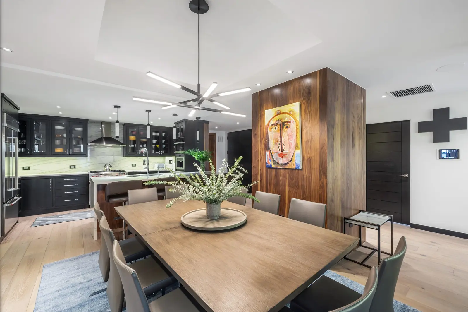 Modern kitchen and dining room with black cabinets and a wooden dining table